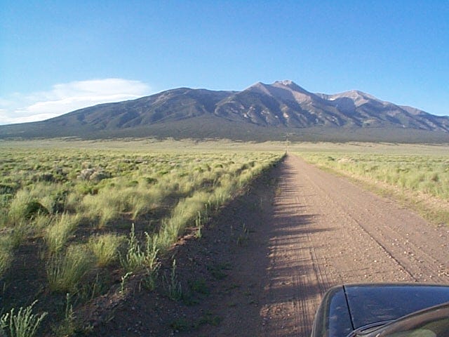 Area photo - dirt road heading toward Mt. Blanca across the San Luis Valley floor, representative of the terrain near Blanca, CO (APN 70303930)