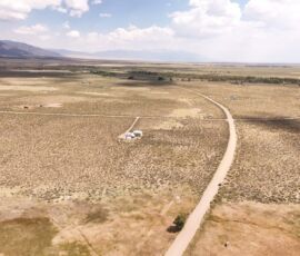 Aerial overview of the Baca Grande area looking toward the Sangre de Cristo range, showing neighboring developed lots and the open valley, APN 460324300062