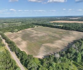 Mid-altitude aerial showing field with paved 18th Street West access road and distant lake, Necedah, WI (LOT 2)