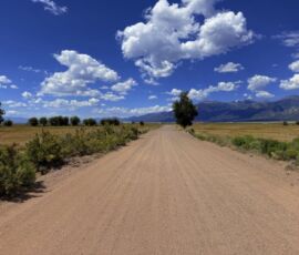 Ground-level view looking down Camino del Rey dirt road toward the Sangre de Cristo Mountains, Baca Grande Grants, APN 460324300062